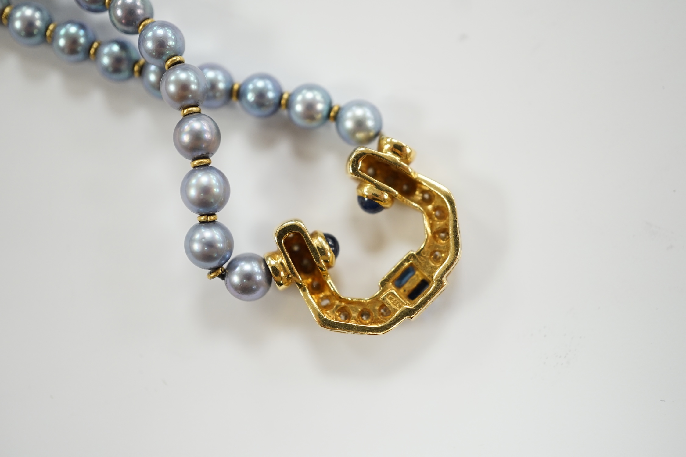 A modern single strand blue cultured pearl necklace, with 750 yellow metal, sapphire and diamond set pendant and yellow metal clasp, 42cm.